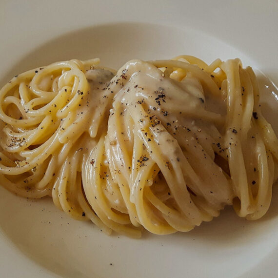 spaghetti cacio e pepe on white plate
